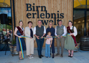 Beim „Durchschneiden“ des Bandes: Mostkönigin Anna Metz, LEADER Region Moststraße-Obfrau Michaela Hinterholzer, Bürgermeister Lukas Michlmayr, Landeshauptfrau Johanna Mikl-Leitner mit Anna Kogler, Stadtrat Johann Kogler und die Mostkönigin-Stellvertreterin Melanie Jagersberger. ©NLK Pfeiffer